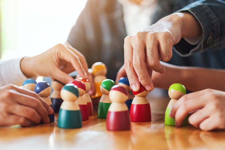 people selecting wooden figures